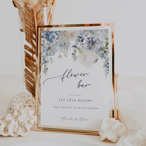 Dusty blue flower bar sign with floral print, framed in light wood, text 'Let love bloom'.