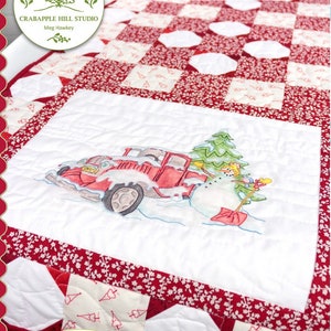 Hand-embroidered quilt with red and white checker blocks and tractor-themed center