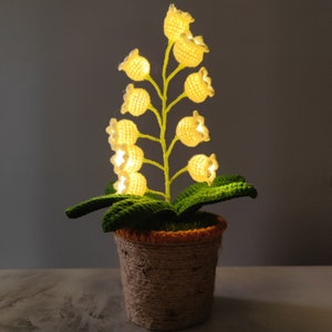 Crochet flower night light lamp in a small pot with glowing yellow lily blooms