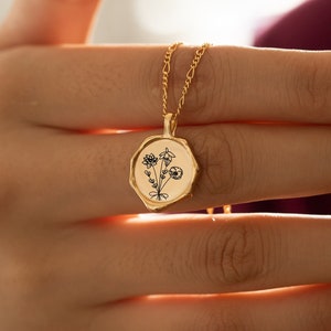 Gold birth-flower necklace with round pendant and botanical engraving on chain