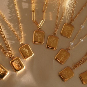 Gold birth-flower charm necklace with multiple small floral pendant charms and chain