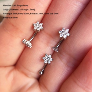 Silver curved barbell earrings with small clear flower gems on ends