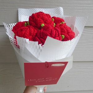 Handmade crochet flower bouquet with red rose-shaped blooms in white wrap