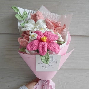 Handmade crochet flower bouquet wrapped in pink paper with multicolor blossoms