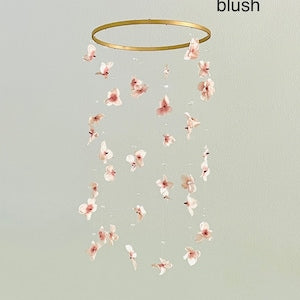Blush floral baby mobile with dangling flower ornaments from a gold-tone ring