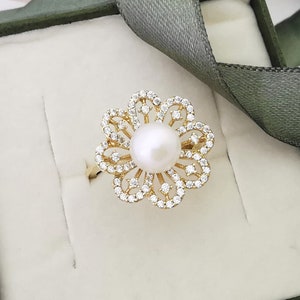 14K gold floral ring with round pearl center and small crystal accents