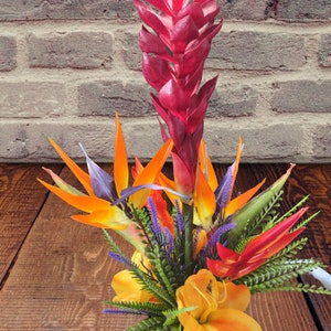 Artificial tropical silk flower centerpiece with orange, blue, pink blooms and green leaves