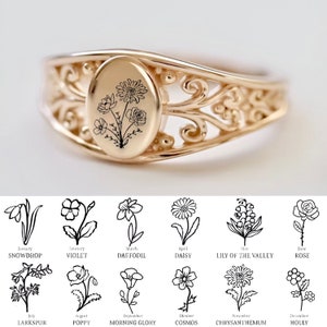Gold-tone oval birth-flower ring with engraved botanical sprig and ornate side filigree
