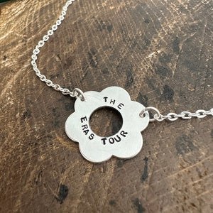 Silver chain necklace with round engraved pendant reading 'THE ERA TOUR'