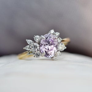 Oval pink gemstone engagement ring with diamond floral cluster halo and prongs