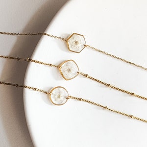 Gold plated fine chain bracelet with hexagon pressed white flower charm