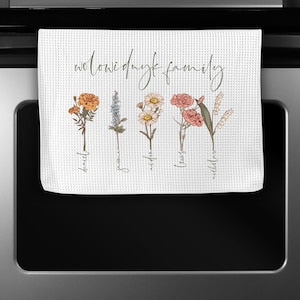 White dish towel with wildflower stems and cursive personalized family text