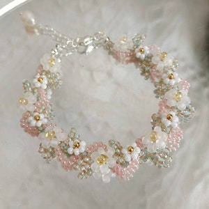 Beaded flower bracelet with white, gold and pink pearl-like beads.