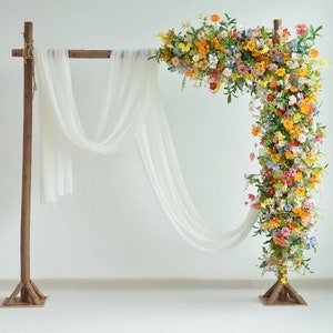 Fall wildflower wedding floral arch with orange, yellow, and red blooms and greenery