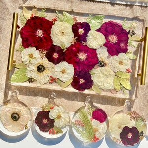 Clear resin flower tray with preserved red, white, and purple blooms and green leaves