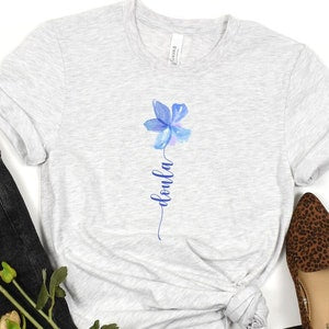 Light gray women's crew-neck shirt with blue flower graphic on front