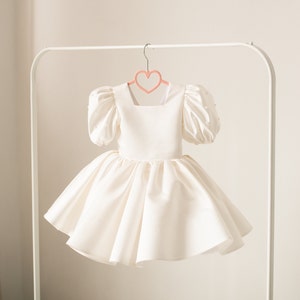 Ivory satin flower girl dress with puff sleeves and full twirly skirt