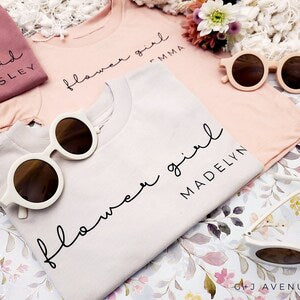 Pink personalized flower girl T-shirt with cursive name and sunglasses pair on top