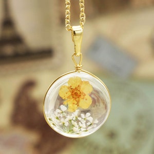 Round resin flower necklace with pressed yellow buttercup and white blossoms on gold chain