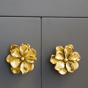 Gold brass flower cabinet knobs with star-shaped petals and central rosette detail