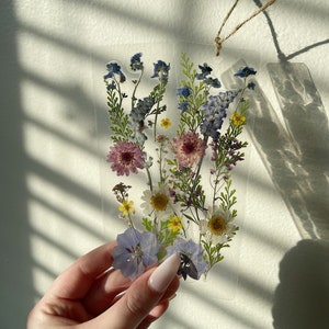 Dried wildflower bookmark with blue and purple pressed flowers and hanging tassel