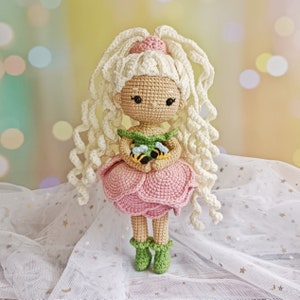 Hand-crocheted flower girl amigurumi doll with bonnet, pink dress, and green boots