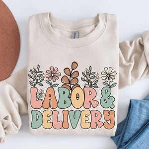 Cream sweatshirt with colorful floral 'LABOR & DELIVERY' front graphic