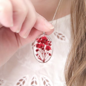 Oval pressed-flower pendant necklace with bright red flower in clear resin, silver chain
