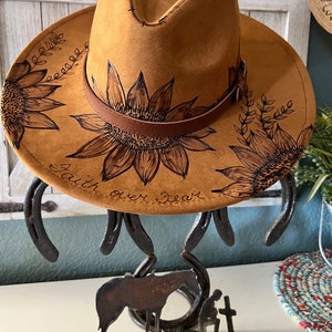 Tan suede cowboy hat with wide brim and hand-burned sunflower floral design