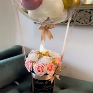 Hot air balloon flower balloon bouquet with pale pink and white roses in dark box