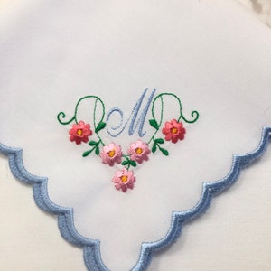 White handkerchief with blue scalloped edge and floral monogram embroidery