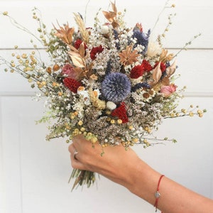 Mixed dried flower bouquet with burgundy, gold, white and navy blooms, handheld