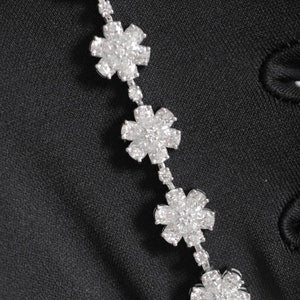Silver-tone tennis bracelet with repeating flower-shaped moissanite stone clusters