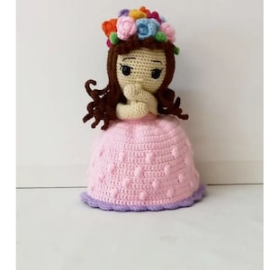 Crocheted amigurumi doll with flower crown, pink dress, and dark hair