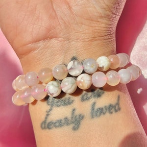 Rose-pink and white round beaded agate bracelet on wrist