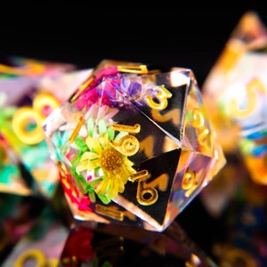 Polyhedral dice set with colorful flower pattern and gold numbered faces