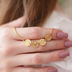 Gold birth-flower family necklace set with four small circular charm pendants