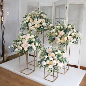 Champagne and cream flower ball table centerpieces with eucalyptus on gold stands