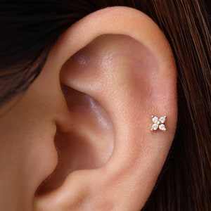 Gold flower cartilage stud earring with small clear gemstone petals