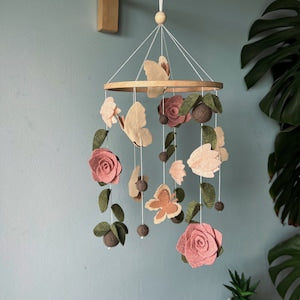 Green felt baby crib mobile with hanging floral shapes and leaf decorations