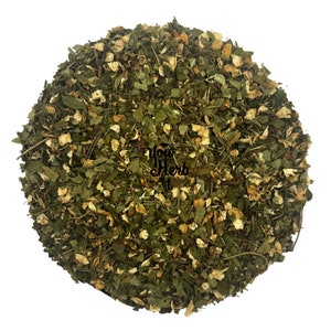 Loose leaf herbal tea blend with dried green leaves and small yellow flowers