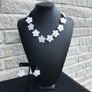 Flower necklace with white blossom charms and pink pearl accents