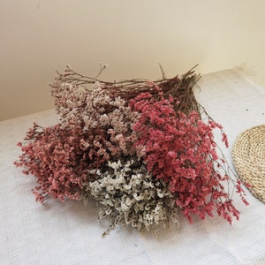 Dried flower arrangement with red and white limonium-style sprigs, bundled like a bouquet