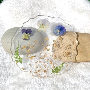 Geode-shaped resin coasters with purple/blue pressed flowers and gold leaf speckles