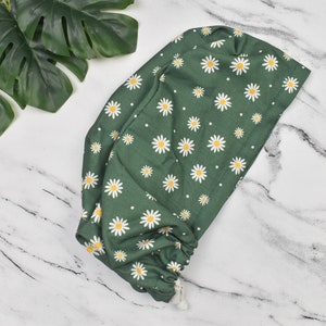 Green scrub cap with white daisy print and adjustable ties