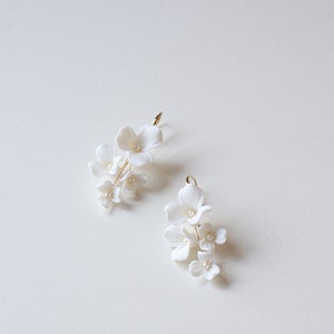 White floral bridal earrings with porcelain blossoms and pearl accents, drop style