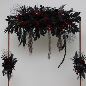 Gothic faux flower arch with burgundy and black blooms, hanging strands and leaf sprigs