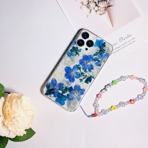 Blue pressed-flower phone case with clear back and matching beaded wrist strap