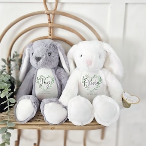 Personalised plush teddy bears, grey and white, each with stitched name heart tag.