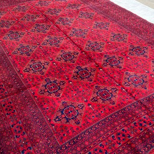 Hand-knotted tribal rug with red field and blue geometric medallion motifs